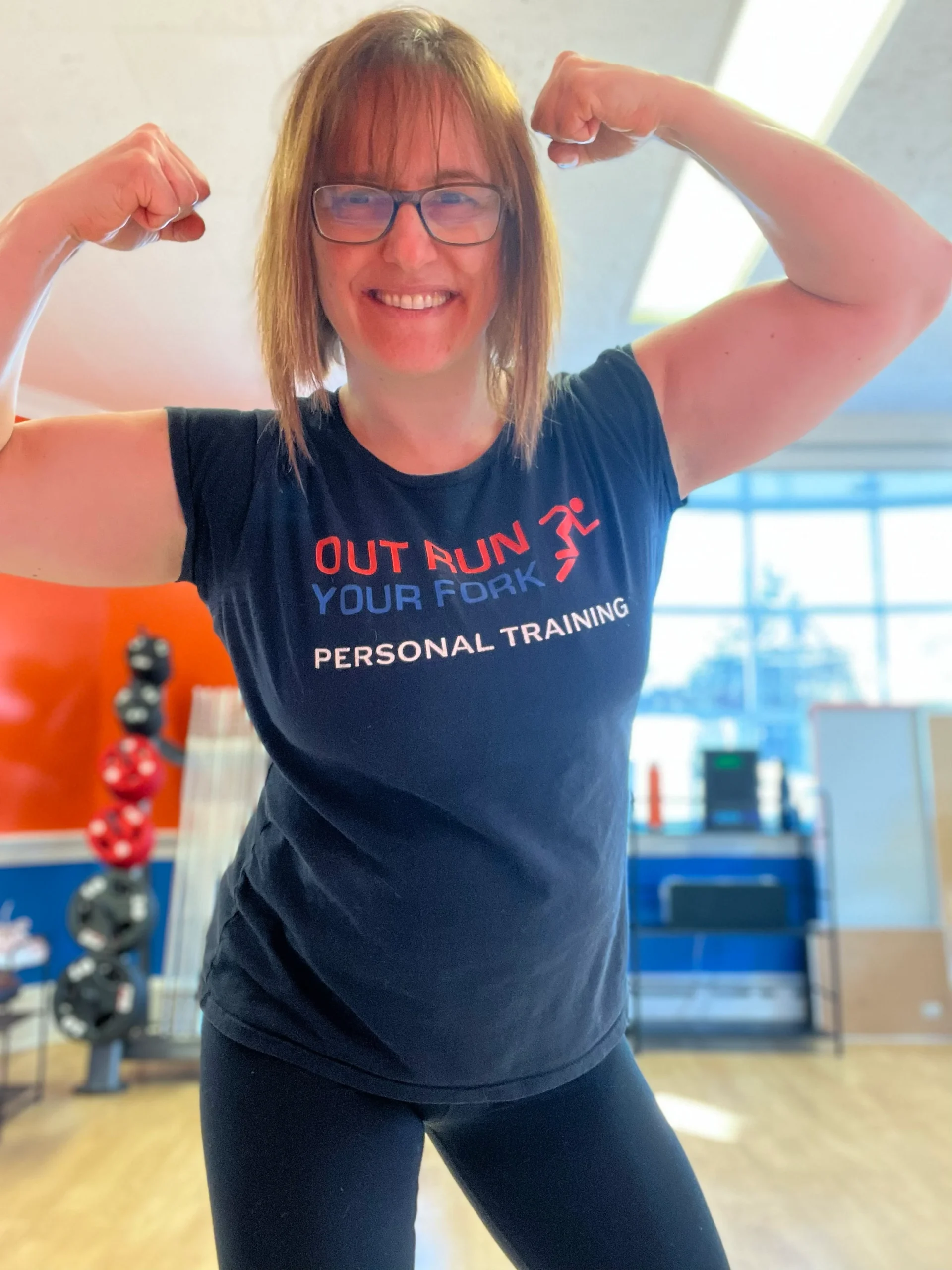 An Out Run Your Fork member flexing and smiling in the Westfield studio